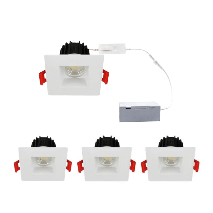 Set of four square recessed ceiling lights with white frames and black lenses on a white background at switchtoled.