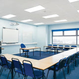 Modern classroom with blue chairs and tables, whiteboards, and large windows.