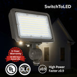 LED flood light with 'SwitchToLED' branding, house in the background, and certification logos.