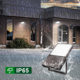 Outdoor light fixture being tested in rain with 'IP65' rating label.