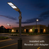 Street light pole with Revolve LED adapter in a parking lot at dusk.