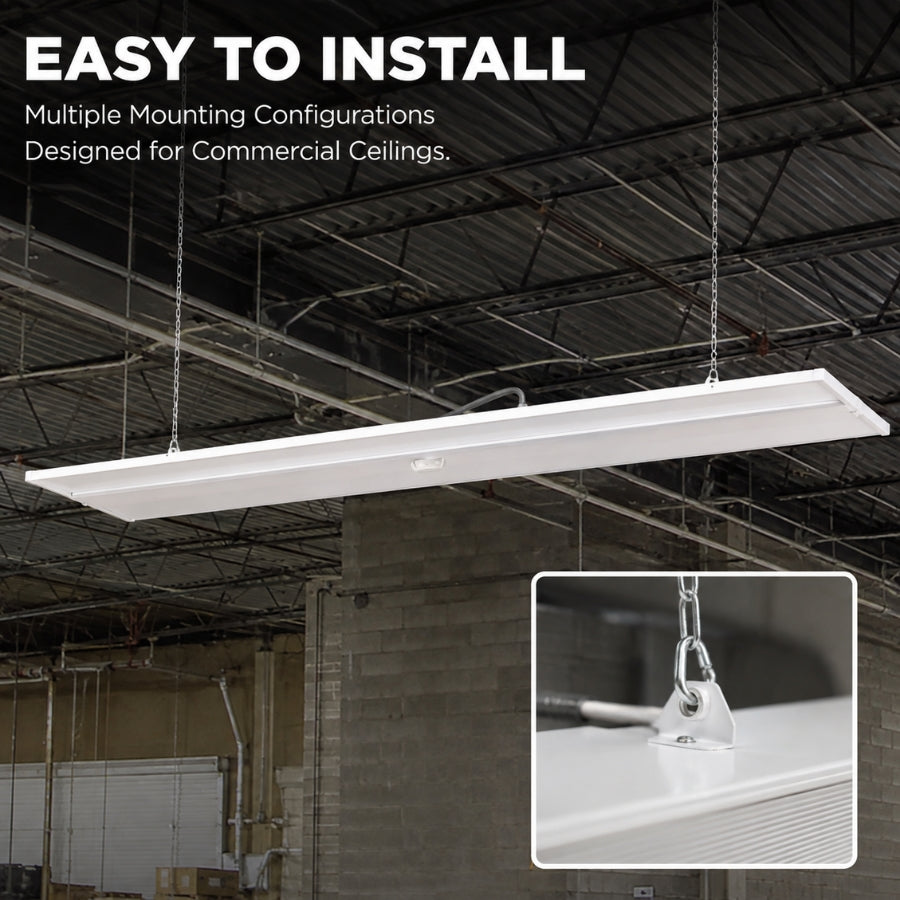 A long rectangular white commercial ceiling light fixture suspended by chains in an industrial warehouse ceiling, with text reading 'EASY TO INSTALL' and a small inset showing a mounting hardware detail.