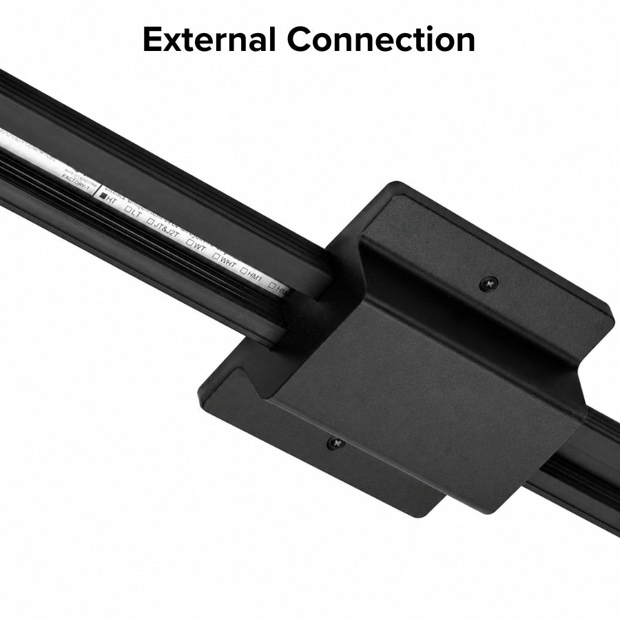 Close-up of a black floating canopy power feed installed on a single circuit track lighting system, showing the external connection between the ceiling junction box and track rail.