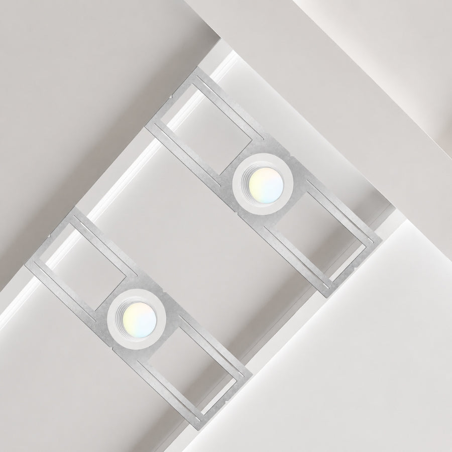 Two recessed ceiling lights in a modern kitchen with white tiled ceiling.