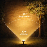 Light fixture with beam angles labeled on a brick wall and tree background