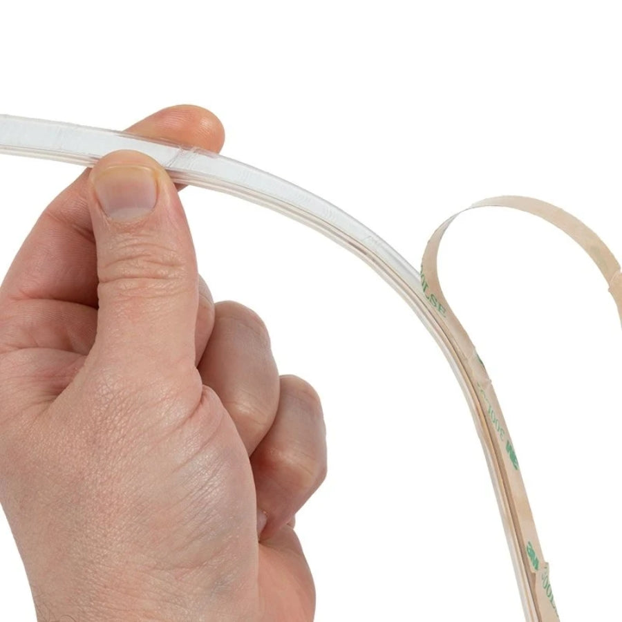 Hand holding a led cob strip light​ against a white background